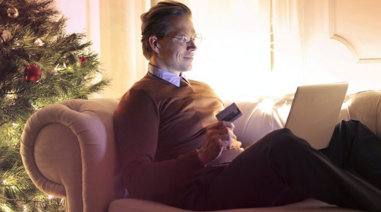 Image of a man on a couch, shopping online